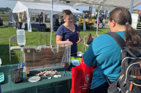 A Wisconsin DNR representative speaks with an attendee at the DNR booth during the 2024 Farm Technology Days event.