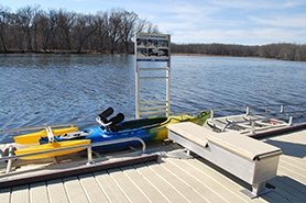 Adaptive kayak with outriggers sitting in the launch area of the universal kayak launch at Merrick State Park, on the backwaters of the Mississippi River.