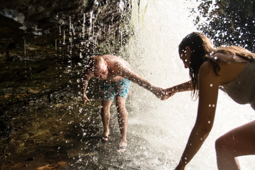 Two people playing beneath a fall at Willow River State Park.