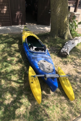 A blue and yellow adaptive kayak with outriggers on the back, which is available at Devil’s Lake State Park.