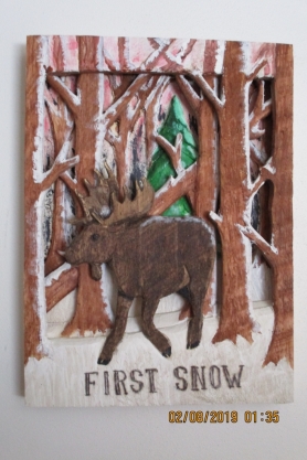An image of a wood carving of a moose in the forest.