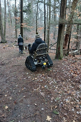 Father and son hike at Point Beach State Forest using an outdoor track wheelchair.