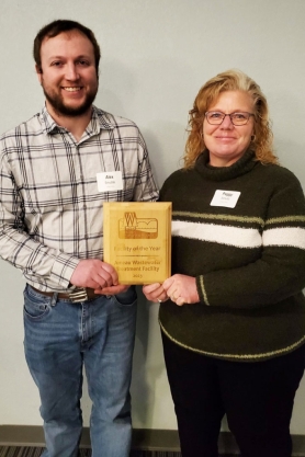 Juneau Wastewater Treatment Facility Staff, Alex Smudde and Peggy Schultz smiling at camera, holding their Facility of the Year award.