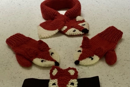 An image of a Knitted red fox scarf, mittens and a headband.