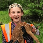 Brilie Esser, a student volunteer, holding a fawn 