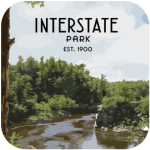 Rocky overlook of river and forest labeled Interstate Park Est. 1900.