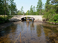 Staff from the DNR take measurements at a highway-stream crossing. A new bottomless culvert structure was installed that allows fish and other aquatic animals to pass.