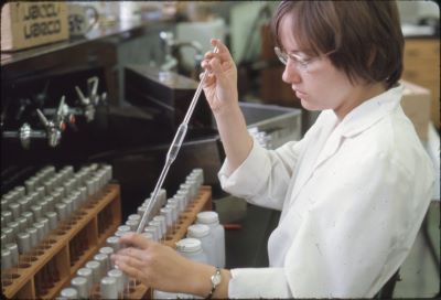 A woman with a pipette, working in a laboratory with lab samples