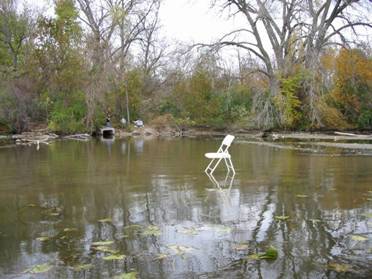 Metal chair sitting in a shallow pool of water