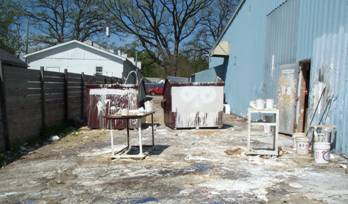 A large amount of white paint and chemicals in a fenced-in outdoor area.